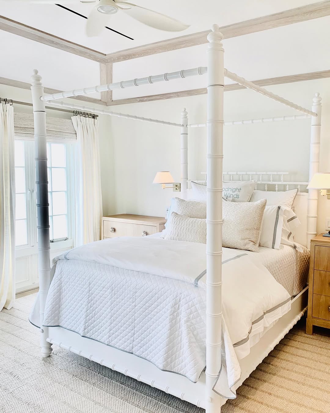 Four-poster bed in white beneath a beamed ceiling