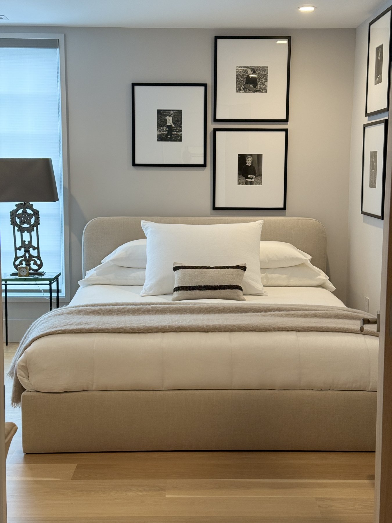 Guest room with an upholstered bed and a gallery of framed photographs