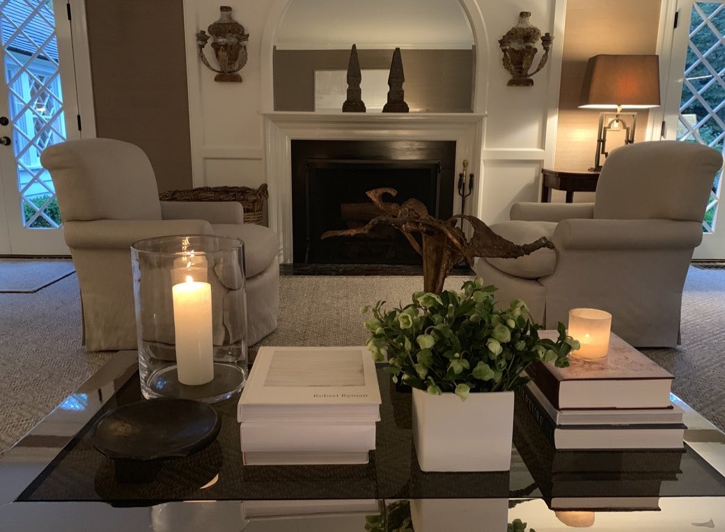 Living room with a fireplace, slipcovered chairs and blue lamps