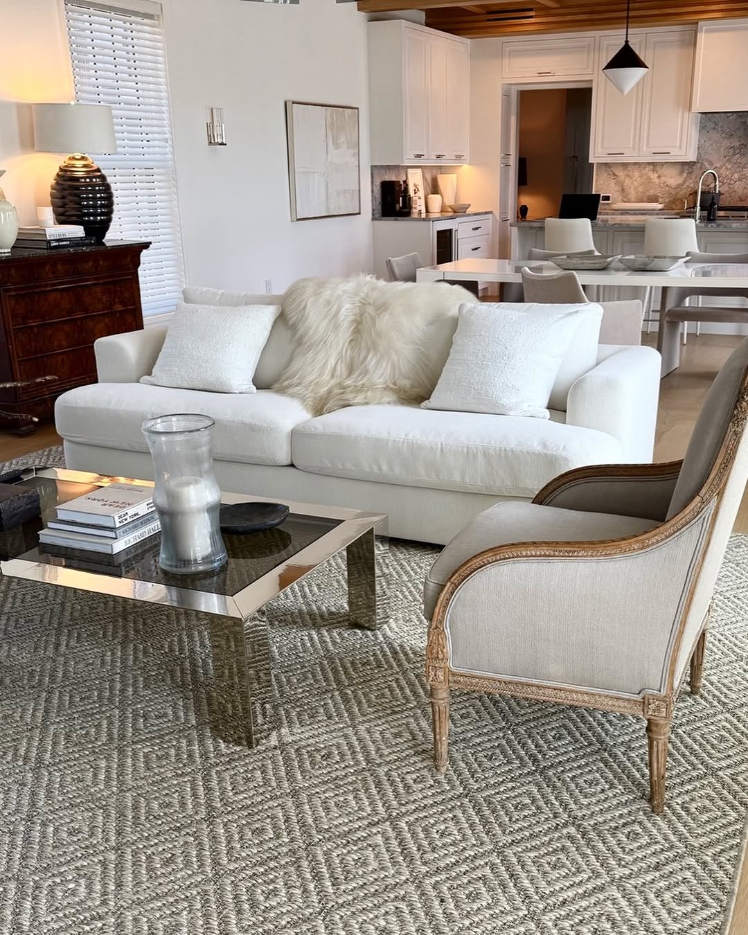 Living room with a linen sofa, geometric rug and a pair of antique chairs