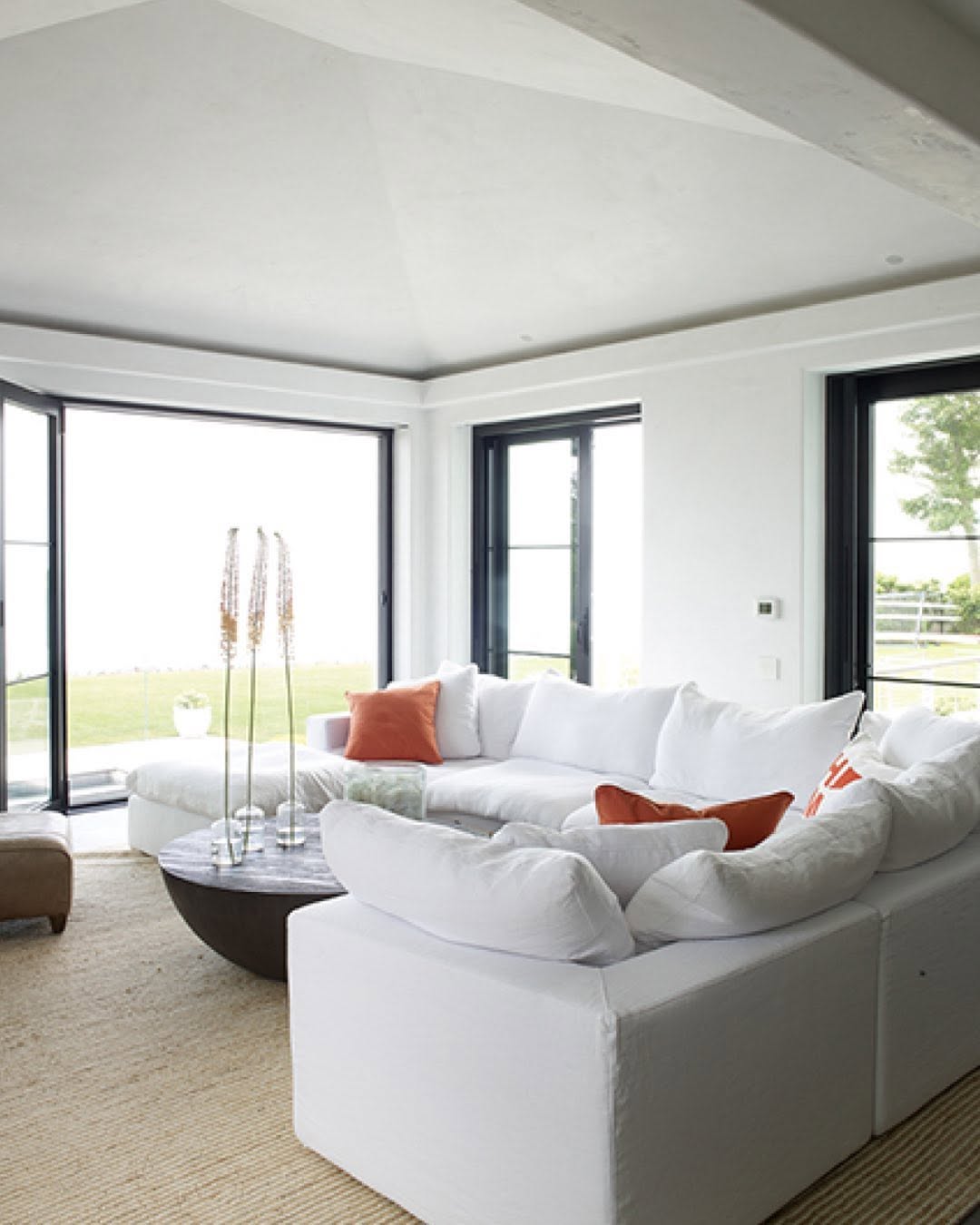 Living room in white and cream opening to the water